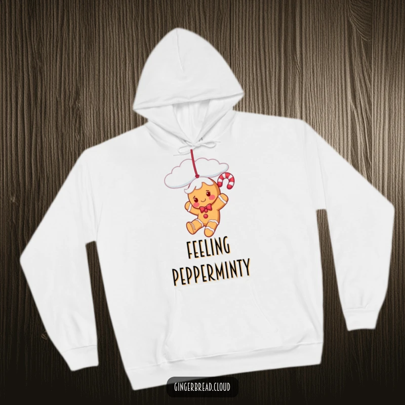 Funny gingerbread candy cane character playfully swinging from a cloud, featured on a warm and cozy hoodie.